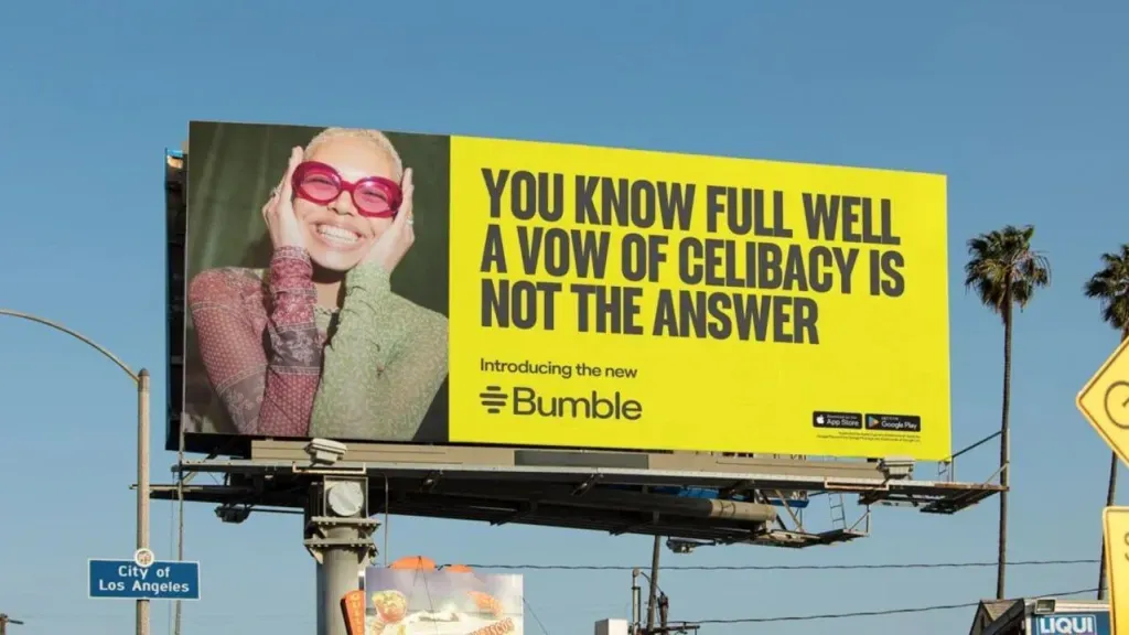 Bumble billboard in Los Angeles reading “You know full well a vow of celibacy is not the answer”, beside a photo of a smiling woman in pink sunglasses