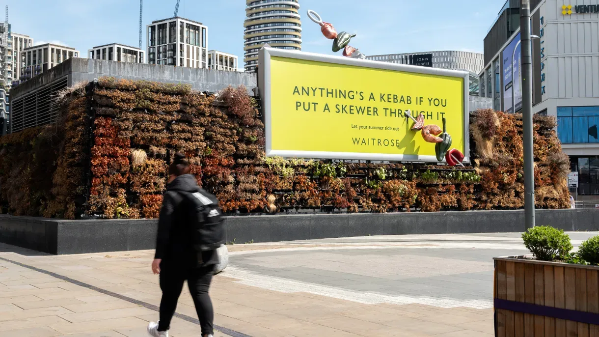 Yellow Waitrose billboard reading “Anything’s a kebab if you put a skewer through it”, with a giant skewer of vegetables bursting through the poster