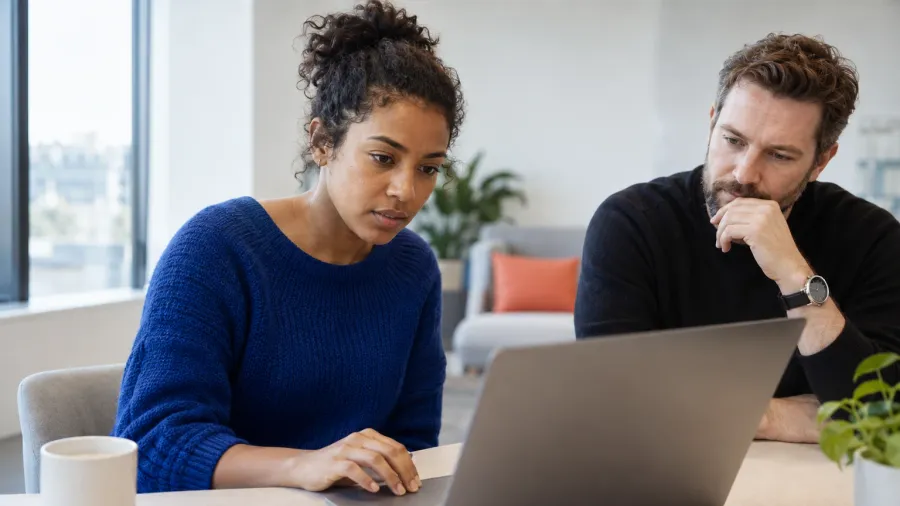 Two people examining information together at a laptop